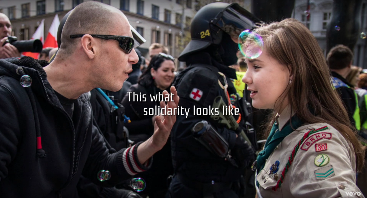 Girl Scout Lucie Myslikova calmly confronting a far-right protester during a rally in the Czech Republic