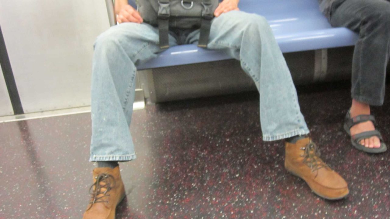 "Manspreading" is the described as a practice where a man adopts a sitting position with his legs wide apart, encroaching on an adjacent seat or seats.
