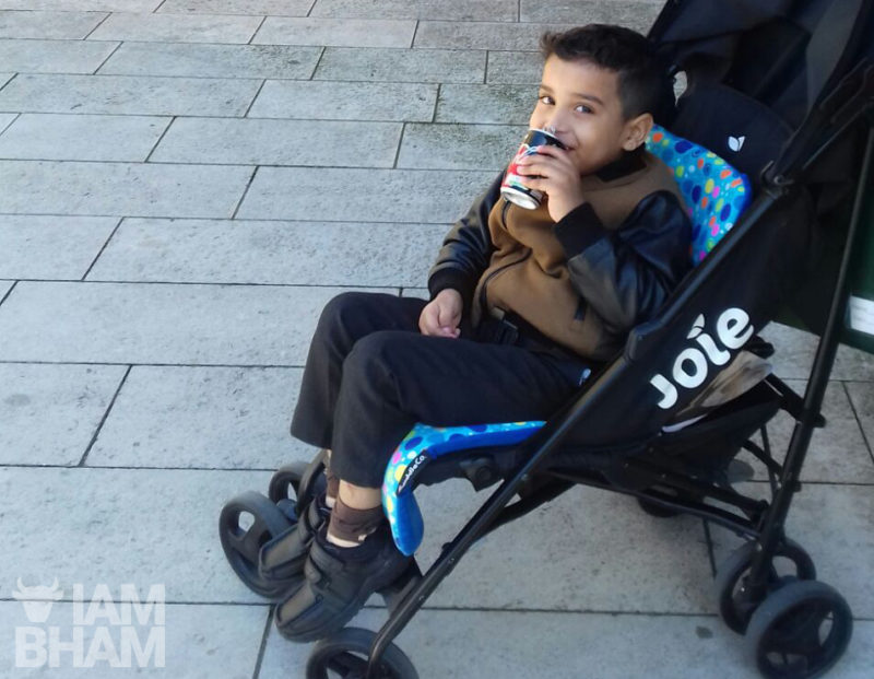 A youngster having a cold drink in the shade outside St. Martin's in the Bullring, Birmingham