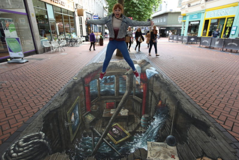 Philipa Bell jumps above the 3D illusion art on New Street in Birmingham
