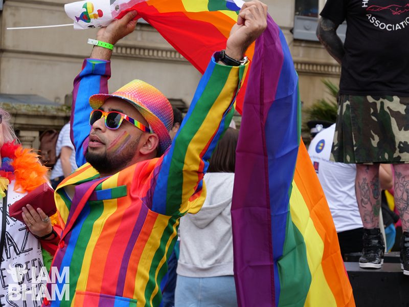 A man with a rainbow suit and flag at Birmingham Pride 2018