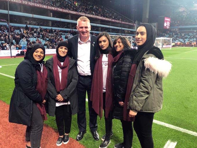 Aston Villa head coach Dean Smith on the pitch with Saathi House members 