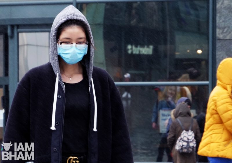 A woman wearing a face mask walks through the Bullring in Birmingham on Wednesday (March 18)