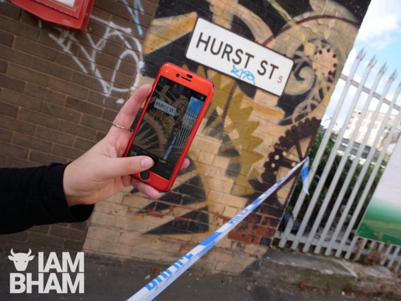 A passer-by captures a photo of Hurst Street on their smartphone following the stabbing incident 