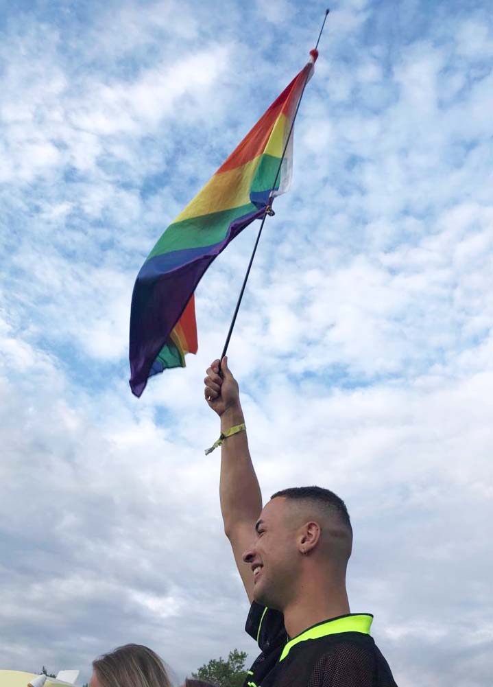 Joshua waving the rainbow flag at Birmingham Pride 