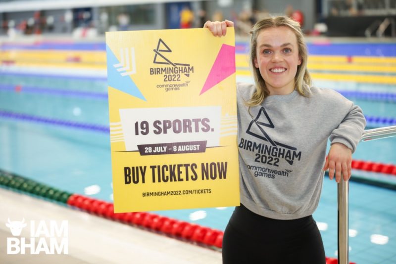 Ellie Simmonds, retired swimming Paralympian and Board Member of Birmingham 2022, holds up a plaque advertising ticket sales