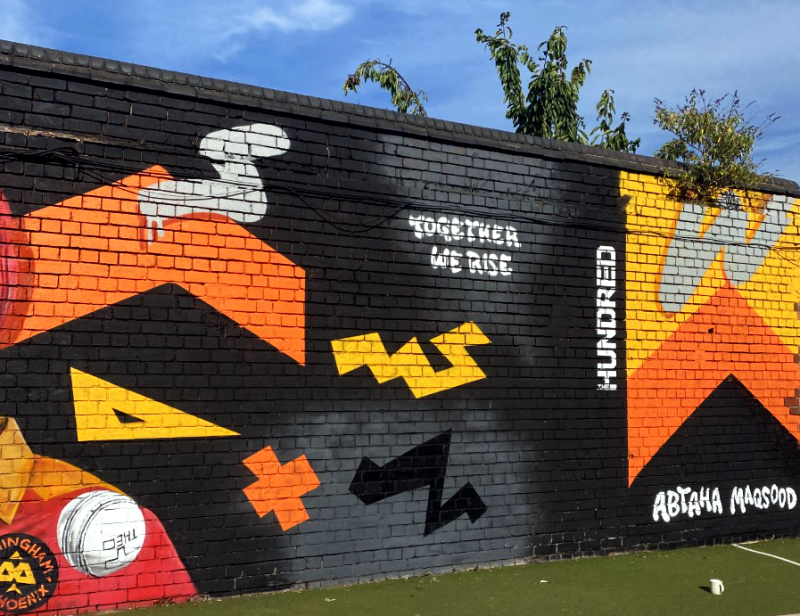 The mural celebrates unity with a slogan that reads "Together We Rise"
