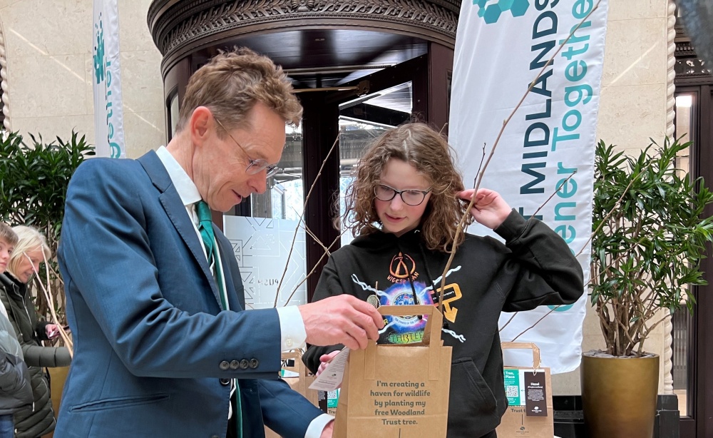 Andy Street, Mayor of the West Midlands, hands a free Woodlands Trust sapling to 13-year-old Betty Green as part of the WMCA