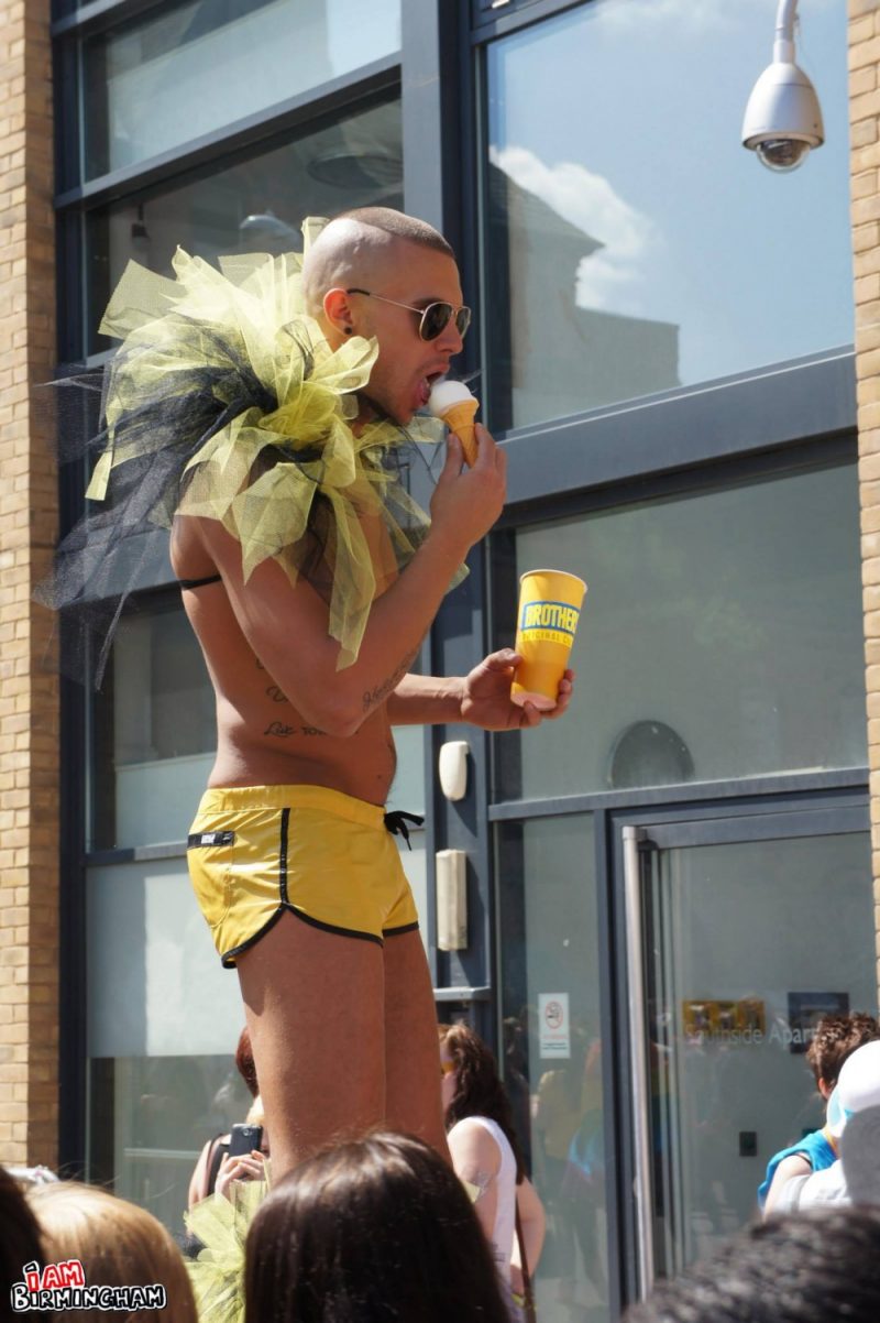 A man in costume on stilts eating ice cream 