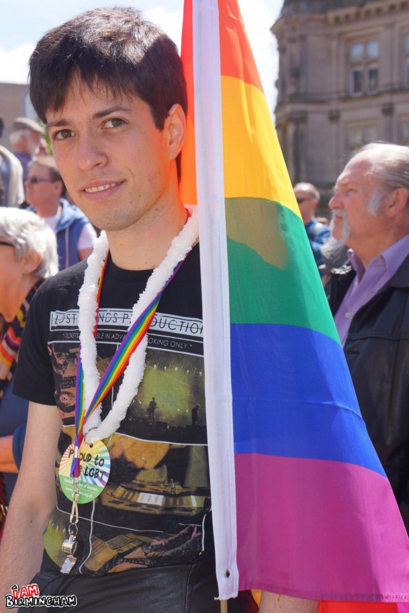 Young person with rainbow flag at Pride 