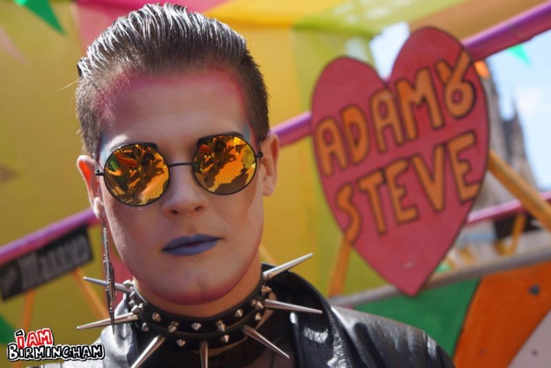 'Adam & Steve' float banner at Birmingham Pride with man with sunglasses in costume 