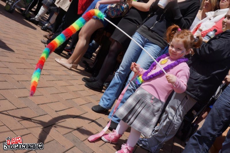 A toddler with a Pride rainbow decoration 