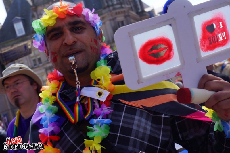 Man with rainbow flowers and whistle at Pride