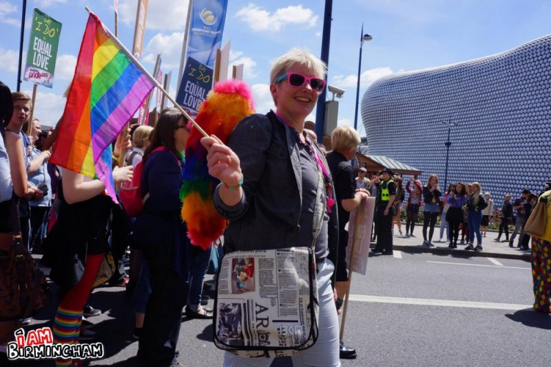 Marching with a Pride rainbow flag past the Selfridges building in Birmingham 