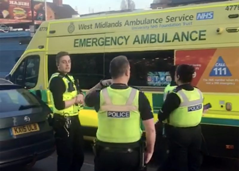 Medics tend to the injured armed robber after his bike crashed into a nearby car 