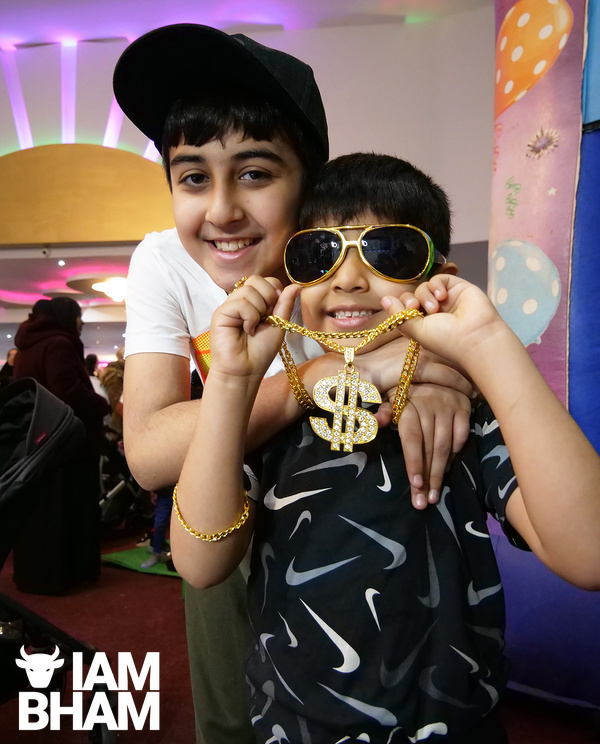 Two young boys dress up for a creative photo session at the Eid bazaar
