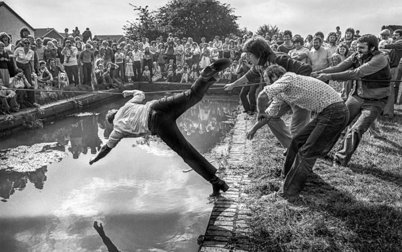 Pub regulars do battle in a tug of war over the canal basin at Nine Locks, Delph in 1978