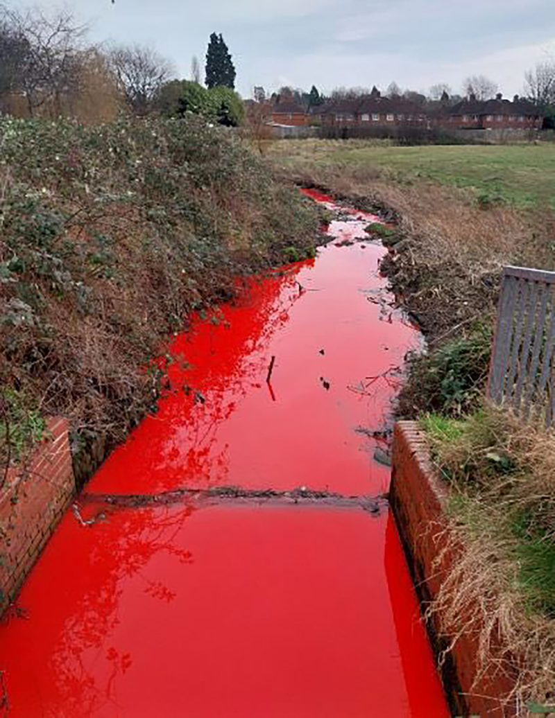 A stream in Birmingham has mysteriously turned bright red, leaving locals bewildered