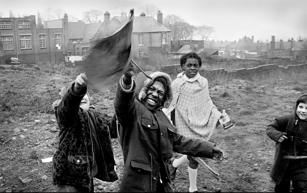 Youngsters plays with a makeshift flag on wasteground off Peel Street, Kates Hill around 1975